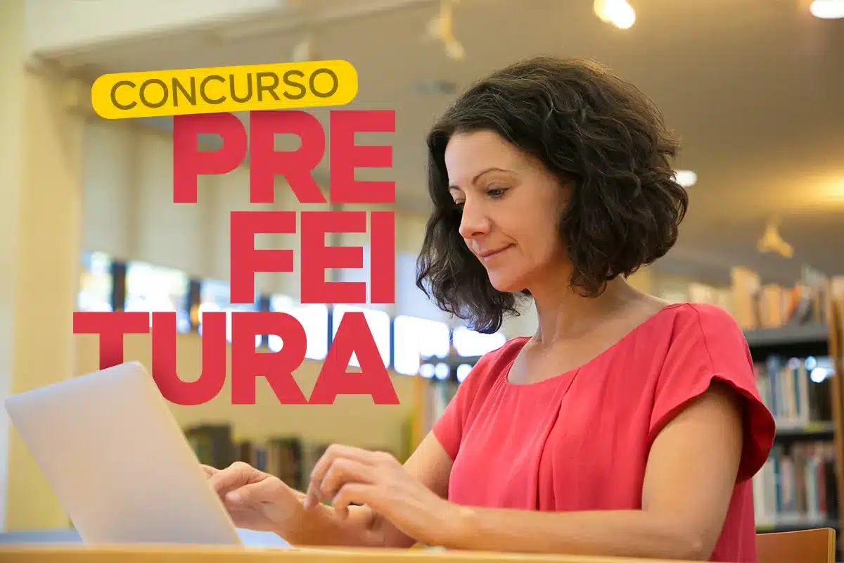 Mulher usando notebook para se inscrever em concurso público da prefeitura em ambiente de biblioteca.