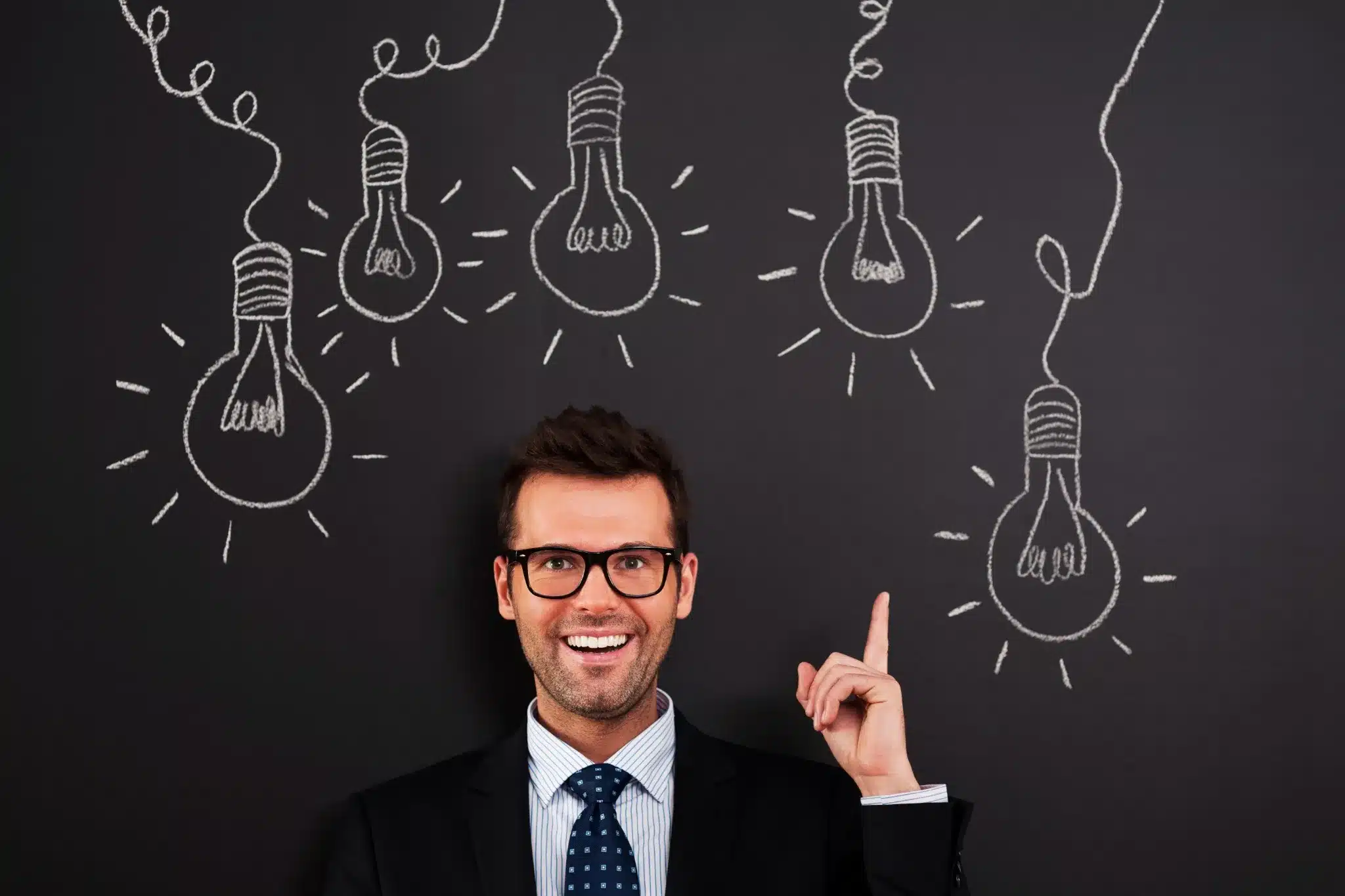 Desenvolvendo habilidades para o crescimento pessoal e profissional Homem sorrindo com expressão de inspiração e luzes representando ideias, com foco em autenticidade, escuta ativa e aprendizado contínuo.