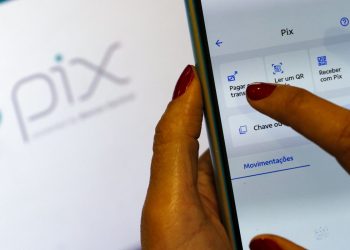 Pessoa usando aplicativo PIX no smartphone para pagar e receber dinheiro com funções rápidas.