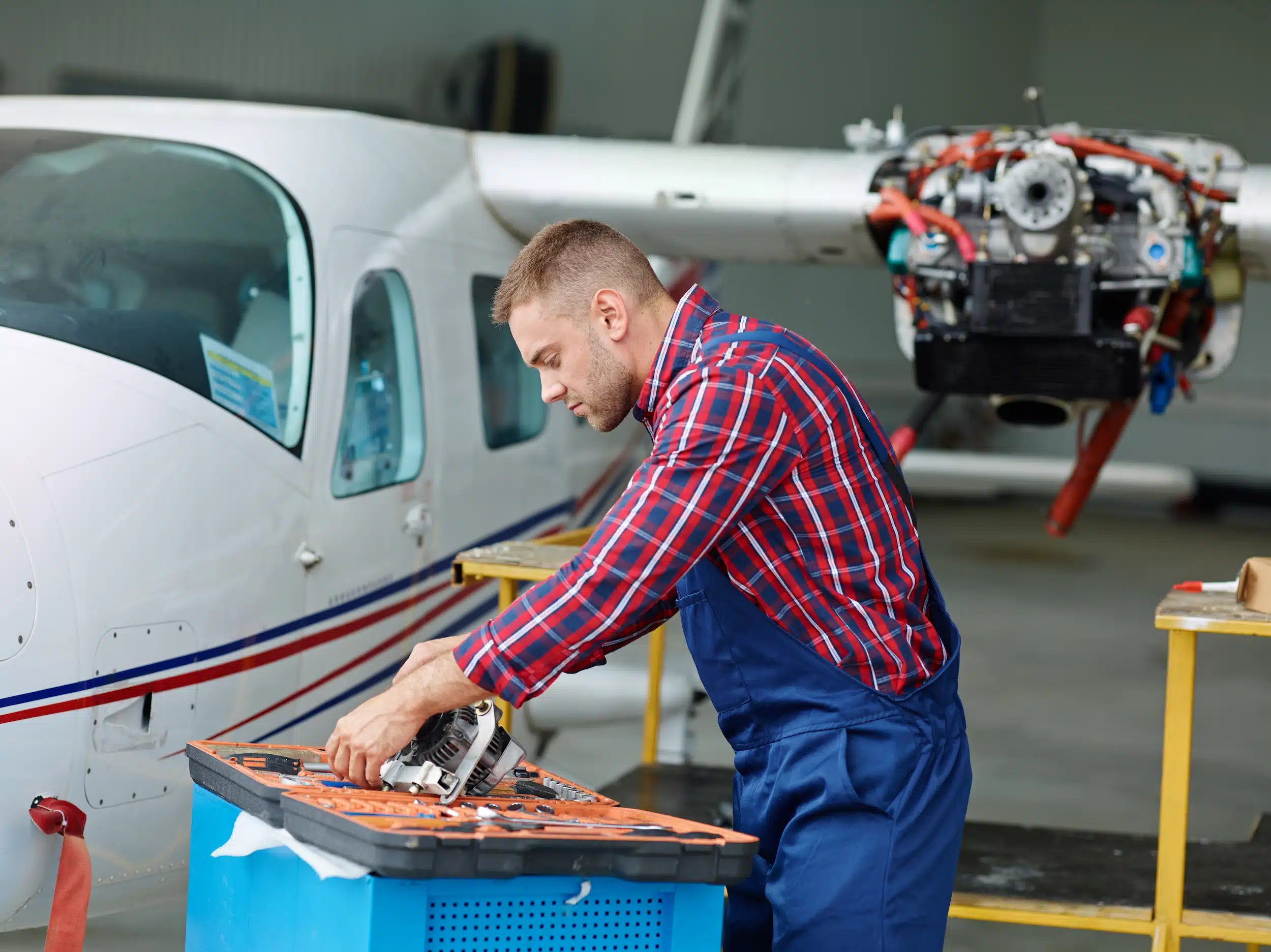 Técnico em aeronaves Técnico realizando manutenção em aeronave, com foco em reparo de motor.