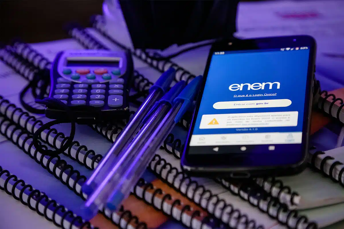 Enem Tela de celular mostrando a página do exame nacional do ensino médio ENEM com uma caneta sobre o aparelho.