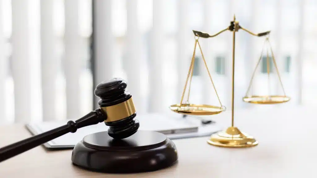 Martelo e balança da Justiça — símbolos do Direito e da imparcialidade. Martelo de juiz e balança dourada sobre mesa, representando a justiça e o equilíbrio nas decisões jurídicas.