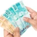 Mãos segurando cédulas de real representam o Saque Calamidade do FGTS, que permite a retirada de até R$ 6.220.