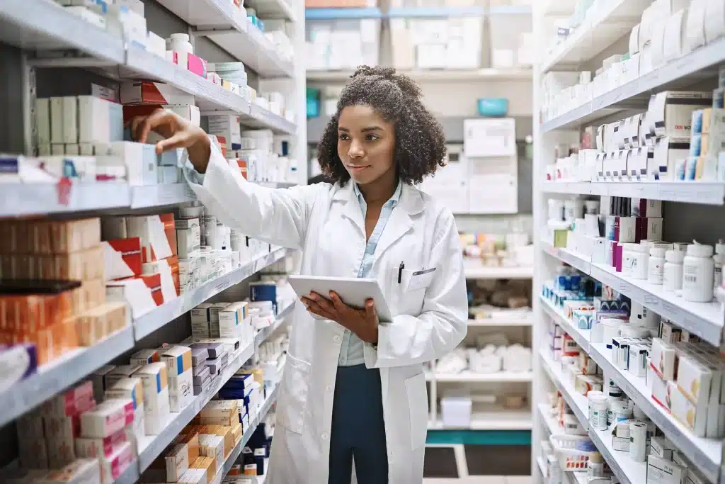 Técnico em Farmácia: Atuação e Organização no Setor Farmacêutico Técnica em farmácia organizando medicamentos em prateleira, ilustrando o curso técnico da área.