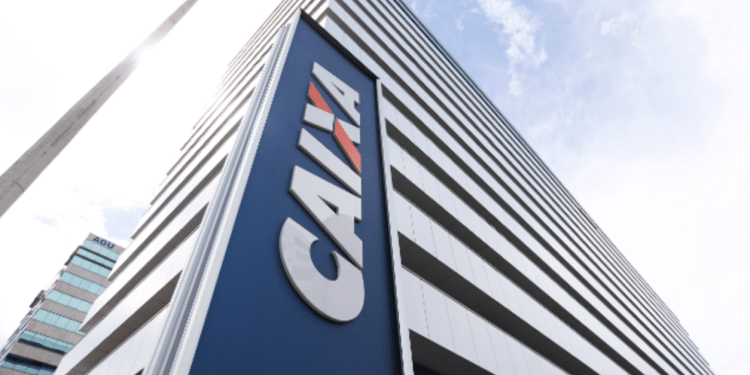 Prédio moderno da CAIXA com logo grande e céu claro ao fundo.