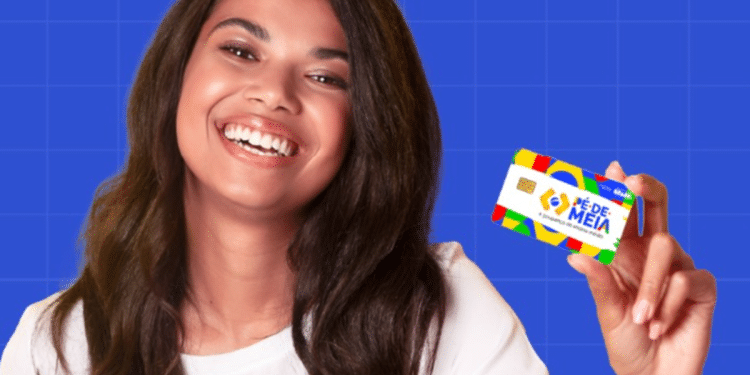 Jovem beneficiária sorridente mostrando cartão Pé-de-Meia em fundo azul