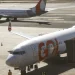Dois aviões da Gol estacionados no aeroporto com um ligado à ponte de embarque