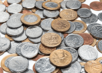 Uma pilha de moedas brasileiras de diferentes valores (5, 10, 50 centavos e R$ 1 real), representando moedas comuns que podem esconder exemplares raros e valiosos.