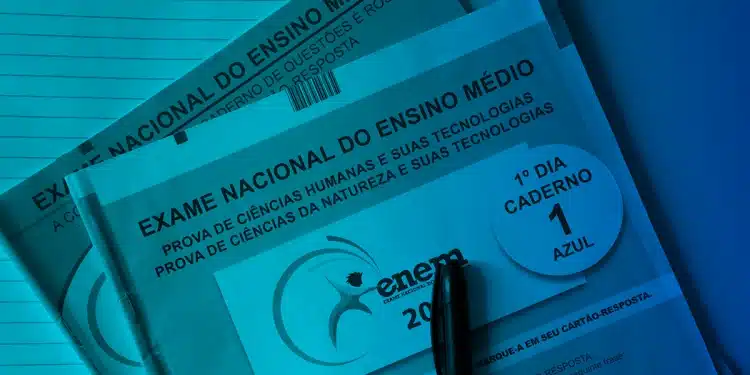 Cadernos de prova azul e rosa do Exame Nacional do Ensino Médio (ENEM) de 2025, com uma caneta preta sobre o caderno do primeiro dia.