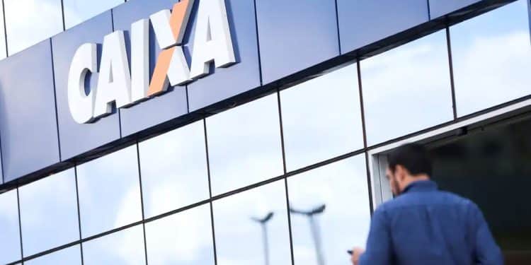 Fachada moderna da Caixa Econômica Federal com um funcionário entrando, simbolizando a oportunidade do concurso Caixa 2025 para carreira pública.