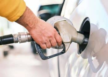 Homem abastecendo carro em posto de gasolina, ilustrando a diferença de preços por estado e a atualização do PMPF para novembro de 2025.