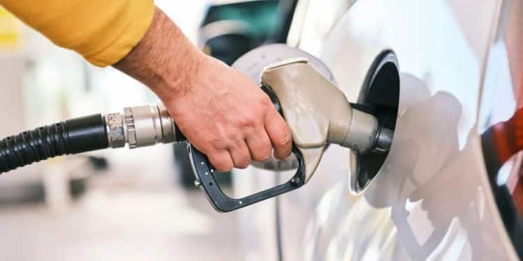 Homem abastecendo carro em posto de gasolina, ilustrando a diferença de preços por estado e a atualização do PMPF para novembro de 2025.