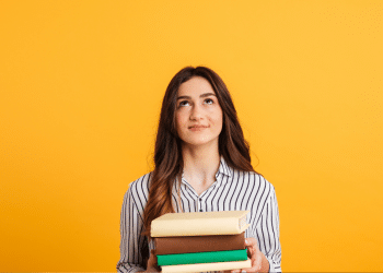 Estudante segura livros representando oportunidades em concursos públicos para câmaras municipais com salários de até R$ 11,9 mil.