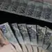 Cédulas de cem e duzentos reais ilustrando diferença de valores entre parcelas do 13º salário.