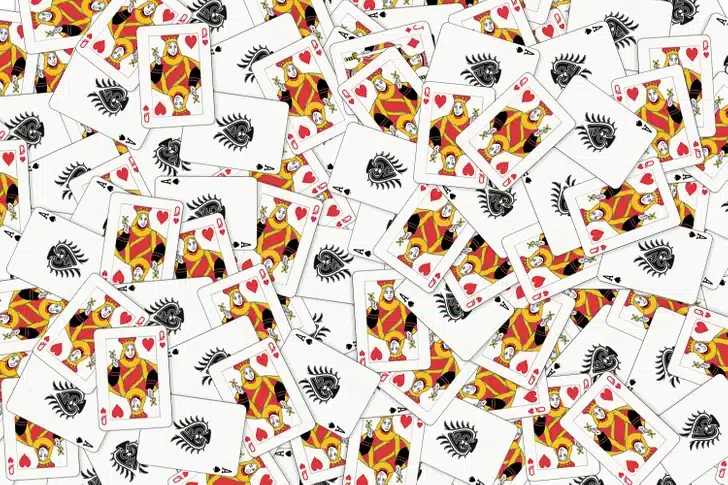 Ache o valete de ouros escondido na imagem mostrando várias cartas de baralho. Teste visual com diversas cartas de baralho espalhadas com destaque para damas de copas.
