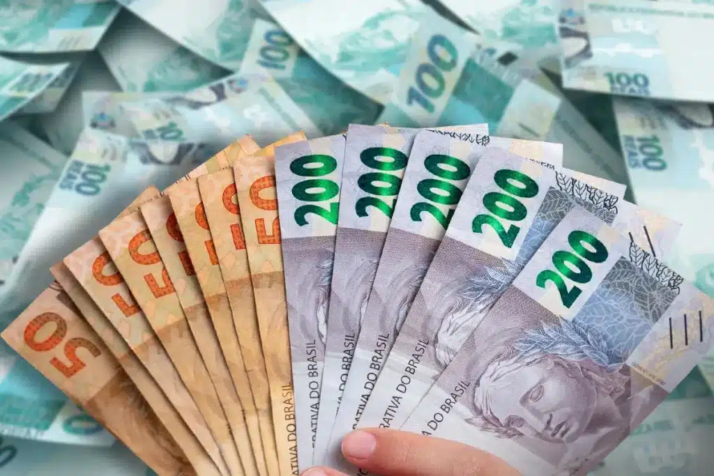 13º Salário Um leque de notas de reais, incluindo cédulas de 50 e 200, simbolizando a chegada do décimo terceiro salário no final do ano.