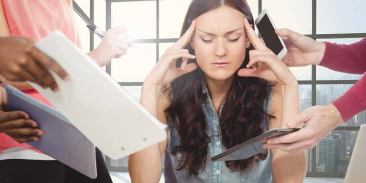 Mulher com expressão ansiosa cercada por várias pessoas oferecendo documentos e dispositivos eletrônicos em escritório moderno.