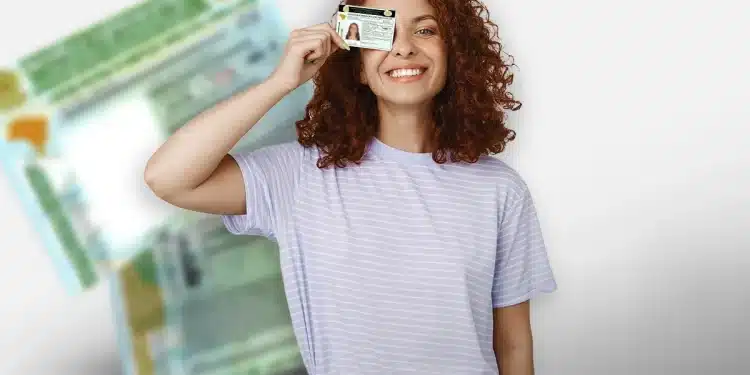 Jovem mulher sorrindo e segurando carteira de motorista perto do rosto com fundo desfocado.