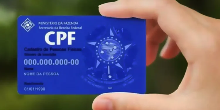 Close na mão segurando o cartão CPF azul da Secretaria da Receita Federal do Brasil