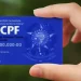 Close na mão segurando o cartão CPF azul da Secretaria da Receita Federal do Brasil