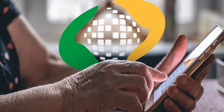 Mãos de uma pessoa idosa utilizando um celular, com o símbolo do INSS em destaque.