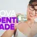 Pessoa sorrindo e segurando a nova Carteira de Identidade Nacional, com óculos, em fundo branco.