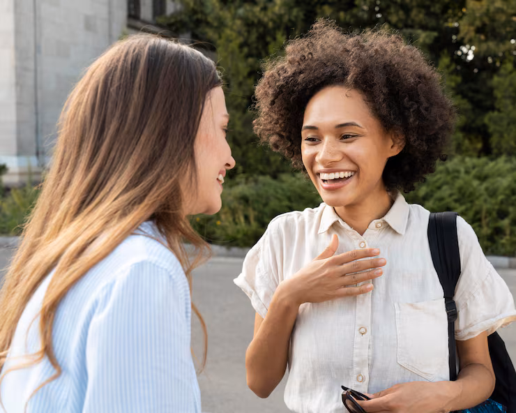 Formas de agradecer em espanhol em conversas cotidianas. Amigas conversando ao ar livre enquanto praticam espanhol em um ambiente informal.