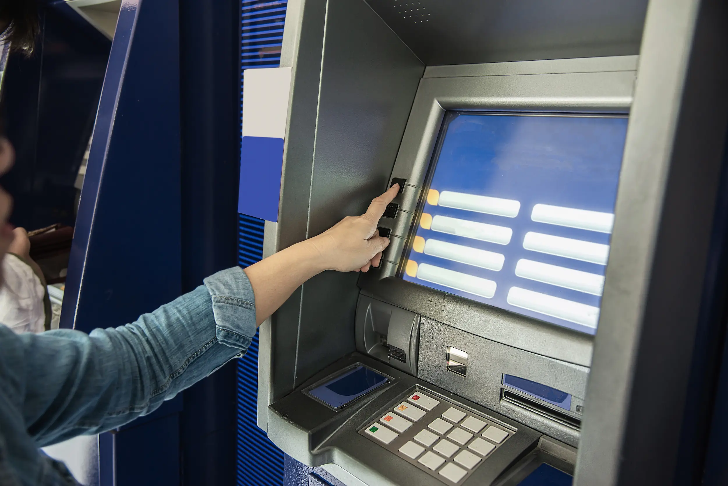 Atendimento bancário no fim do ano Cliente utilizando caixa eletrônico enquanto verifica informações sobre o funcionamento da CAIXA e do Banco do Brasil no dia 24 de dezembro.