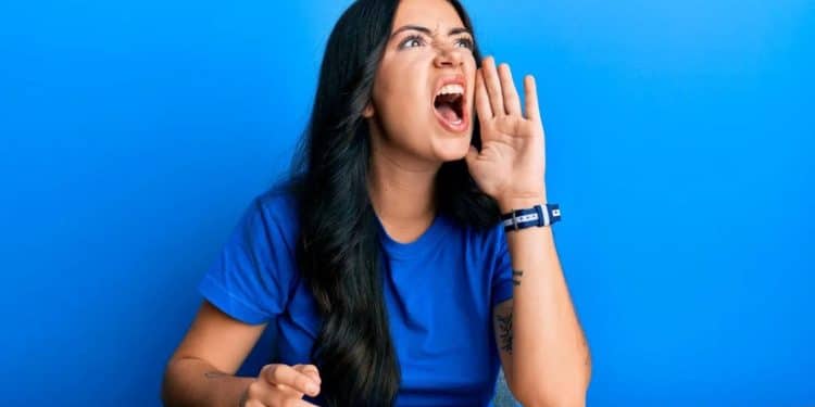 Mulher falando alto e gesticulando, representando o impacto da linguagem na comunicação e no comportamento.