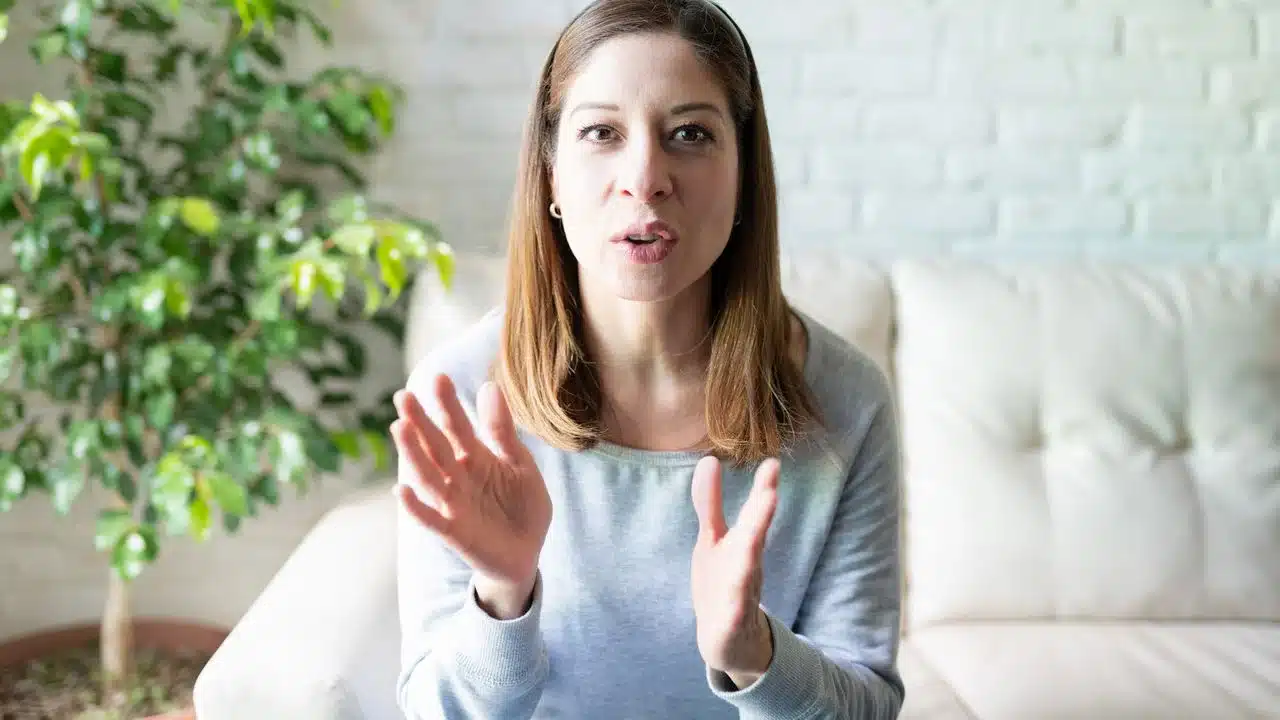 Expressões que influenciam atitudes e comportamentos. Mulher gesticulando enquanto fala, ilustrando o impacto das palavras no comportamento e nas relações.