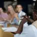 Grupo de pessoas em uma reunião de escritório, com um participante falando enquanto os outros escutam.