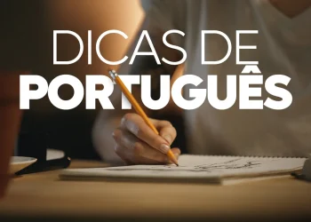Close das mãos de uma pessoa utilizando um lápis para escrever em um bloco de notas sobre uma mesa de madeira, com o título "Dicas de Português" em letras brancas grandes sobre a cena.