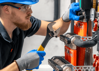Técnico em instrumentação realizando ajuste em sistema industrial de energia, ilustrando profissões técnicas.