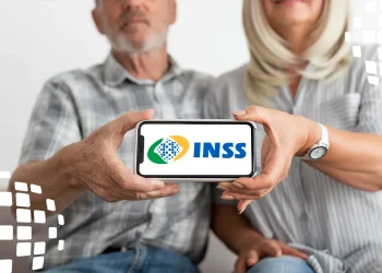 Imagem de dois idosos segurando um celular com a logo do INSS.