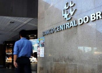 Fachada externa do edifício sede do Banco Central do Brasil com pessoa caminhando