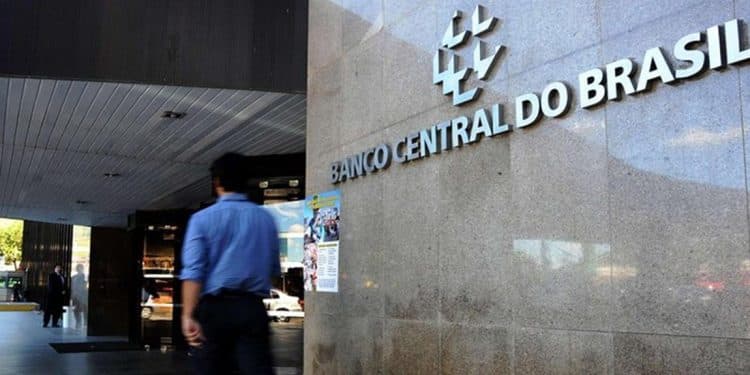 Fachada externa do edifício sede do Banco Central do Brasil com pessoa caminhando
