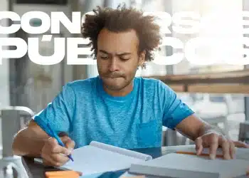 Homem concentrado estudando anotações com caneta em caderno e listas de tarefas ao redor