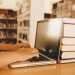 Imagem mostrando um ambiente de estudo com livros e um laptop, representando o contexto de inscrições abertas para processo seletivo e concurso público.
