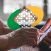 Mãos envelhecidas segurando e usando um smartphone com o logotipo do mundo digital ao fundo