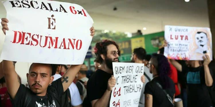 Manifestantes seguram cartazes contra a escala de trabalho 6x1 durante protesto.