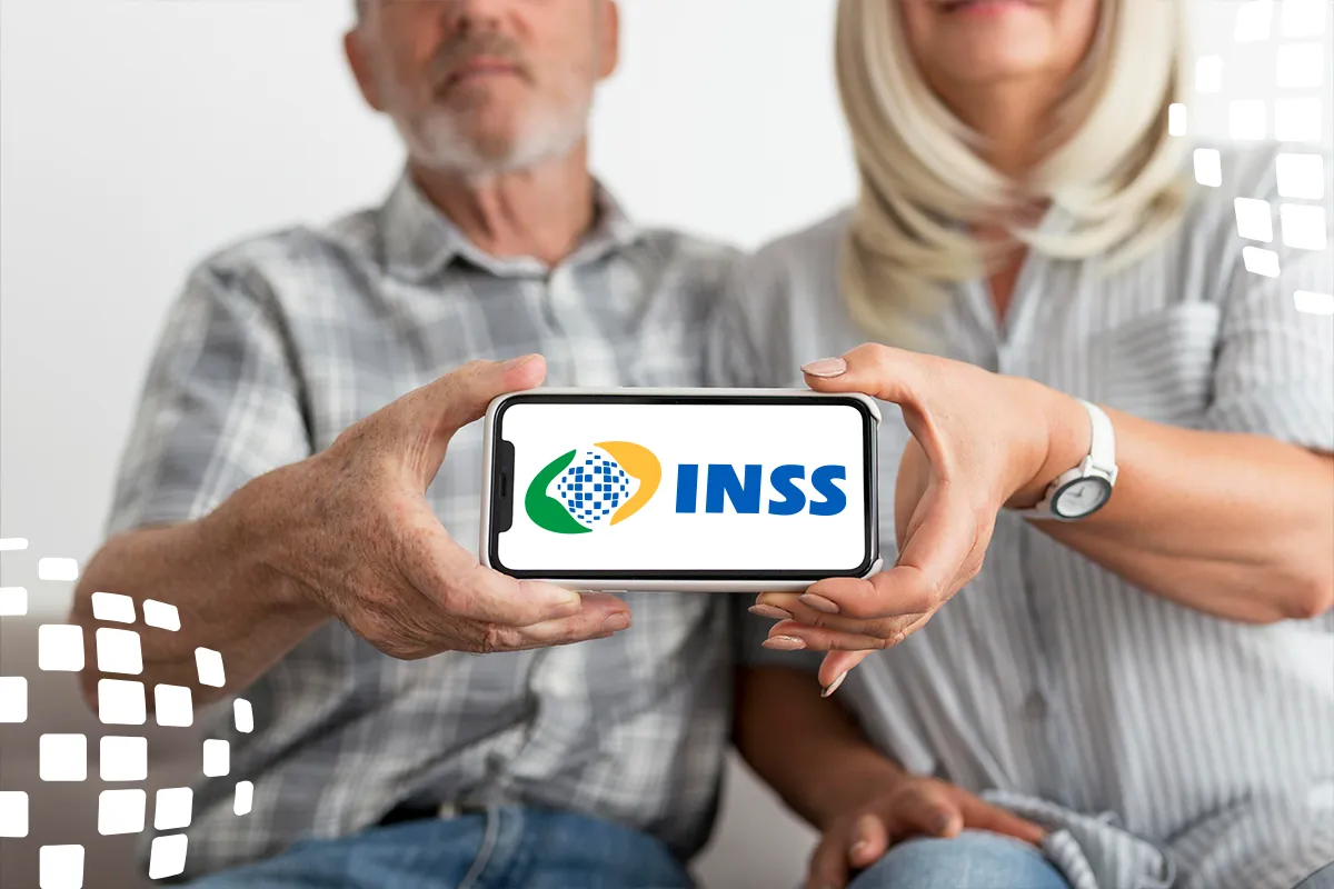 Casal de idosos segurando celular com logo do INSS em destaque