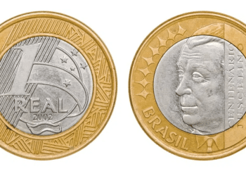 Anverso e reverso da moeda de 1 real brasileira de 2002, comemorativa do centenário de Juscelino Kubitschek, exibindo o rosto de JK e o valor nominal.