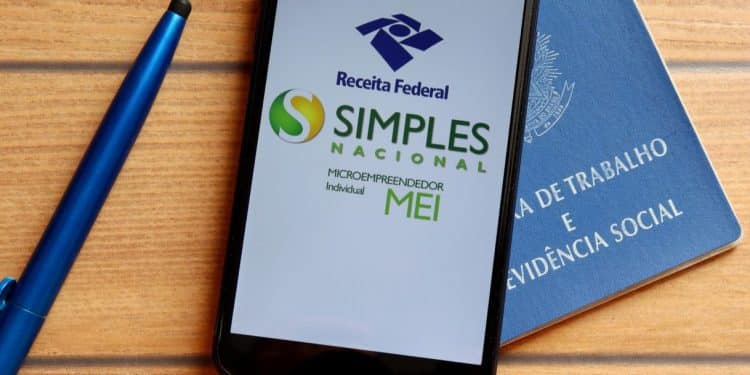 Tela de celular exibindo logo da Receita Federal, Simples Nacional e MEI, com fundo da carteira de trabalho.