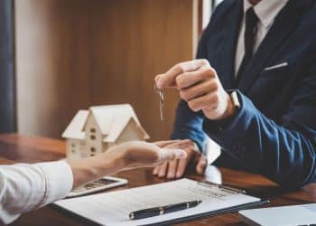 Pessoa recebendo as chaves de uma casa, simbolizando a transação imobiliária.