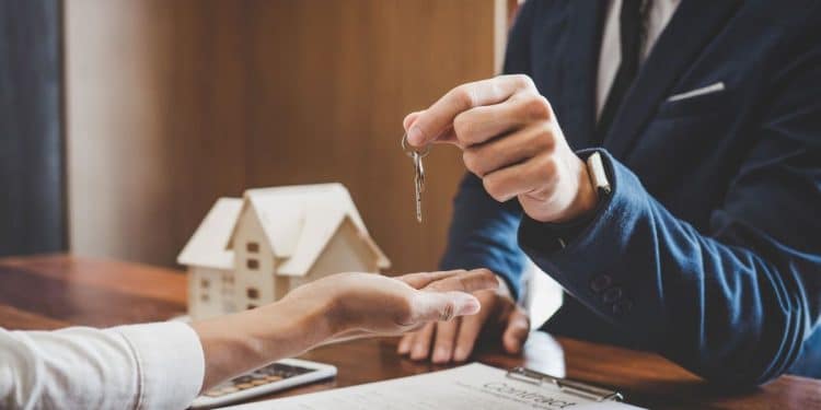 Pessoa recebendo as chaves de uma casa, simbolizando a transação imobiliária.