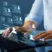 Profissional utiliza computador enquanto perfis digitais representam novas exigências do mercado de trabalho