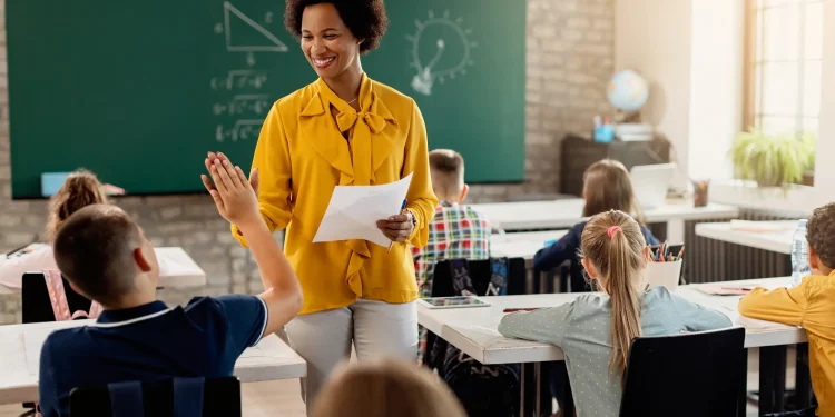 Professora interagindo com alunos em sala de aula, exemplificando o ensino nas redes estaduais.