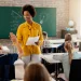 Professora interagindo com alunos em sala de aula, exemplificando o ensino nas redes estaduais.