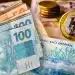 Notas de dinheiro e moedas brasileiras representando os valores do saque-aniversário do FGTS.