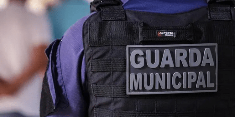 Guarda Municipal usando colete tático preto com a inscrição GUARDIA MUNICIPAL nas costas.